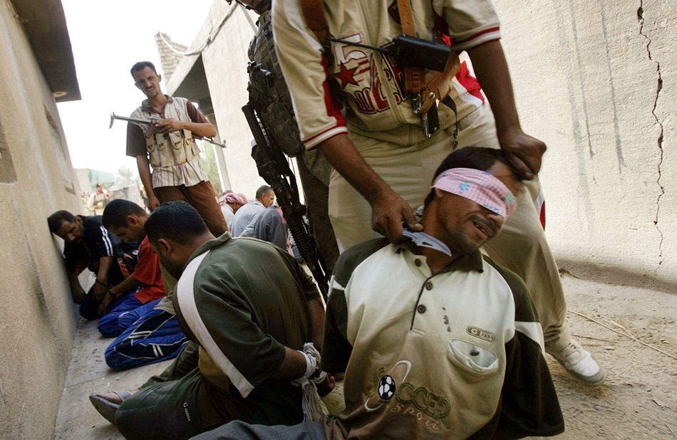 2007. szeptember 6. - az amerikaiak oldalán harcoló szunni milicista kést tart egy fogoly torkához. A polgárháborús káosz lecsillapításában nagy szerepe volt a szunni milicistáknak, akiket Petraeus tábornok állított maga mellé.