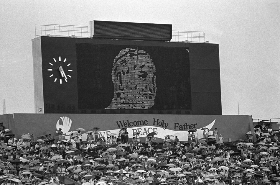1986. november 20. - Szingapúr: köszöntés az eredményjelzőn - a stadionban celebrált szabadtéri mise előtt a helyiek köszöntötték II. János Pált.