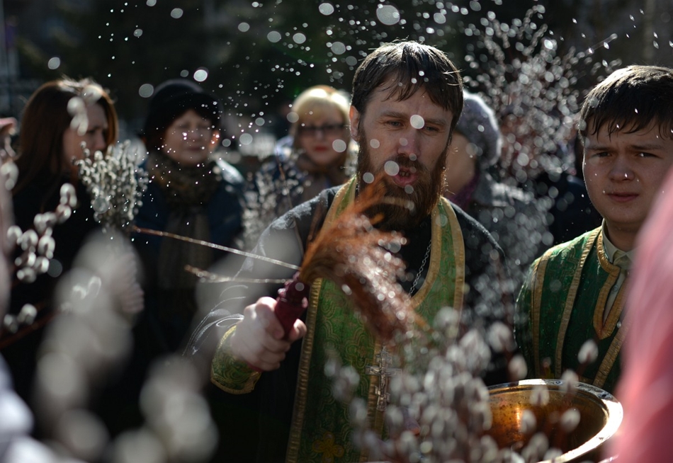Novoszibirszk, Oroszország - pap fűzfaágat szentel, így emlékezve meg Krisztus bevonulásáról Jeruzsálembe